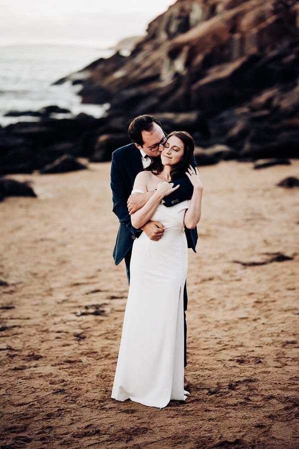 Bride and groom on sand beach acadia national park
