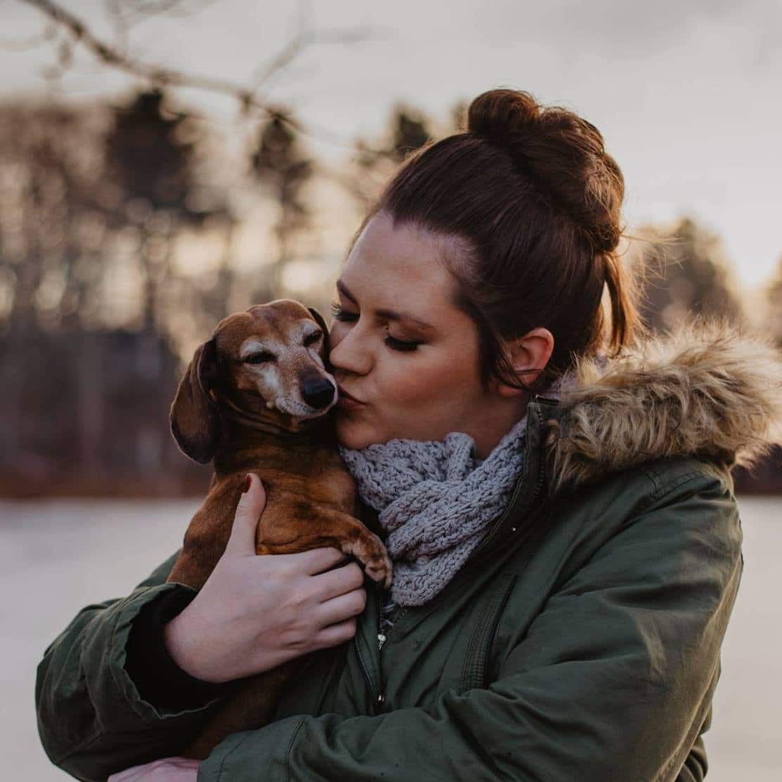 Woman holding dog kissing