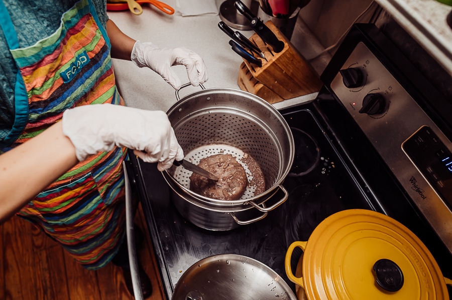 Woman poking steamed placenta with knife