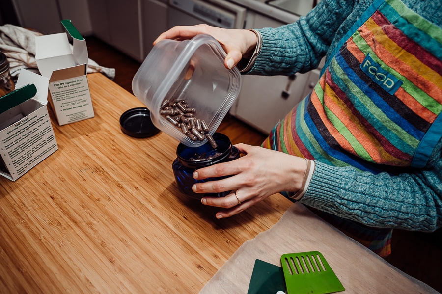 Pouring placenta capsules into jar