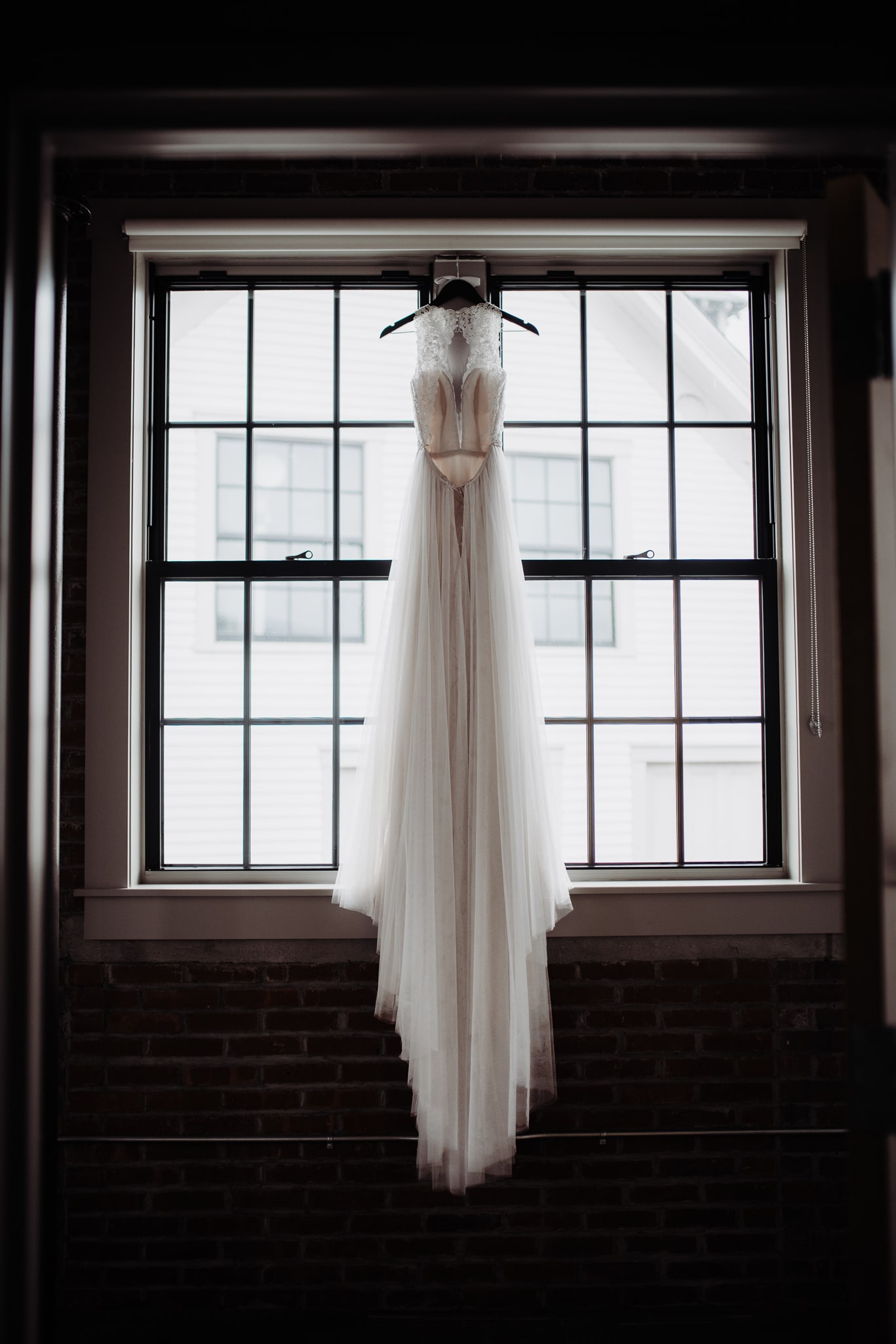 Long Wedding Dress Hanging in Window