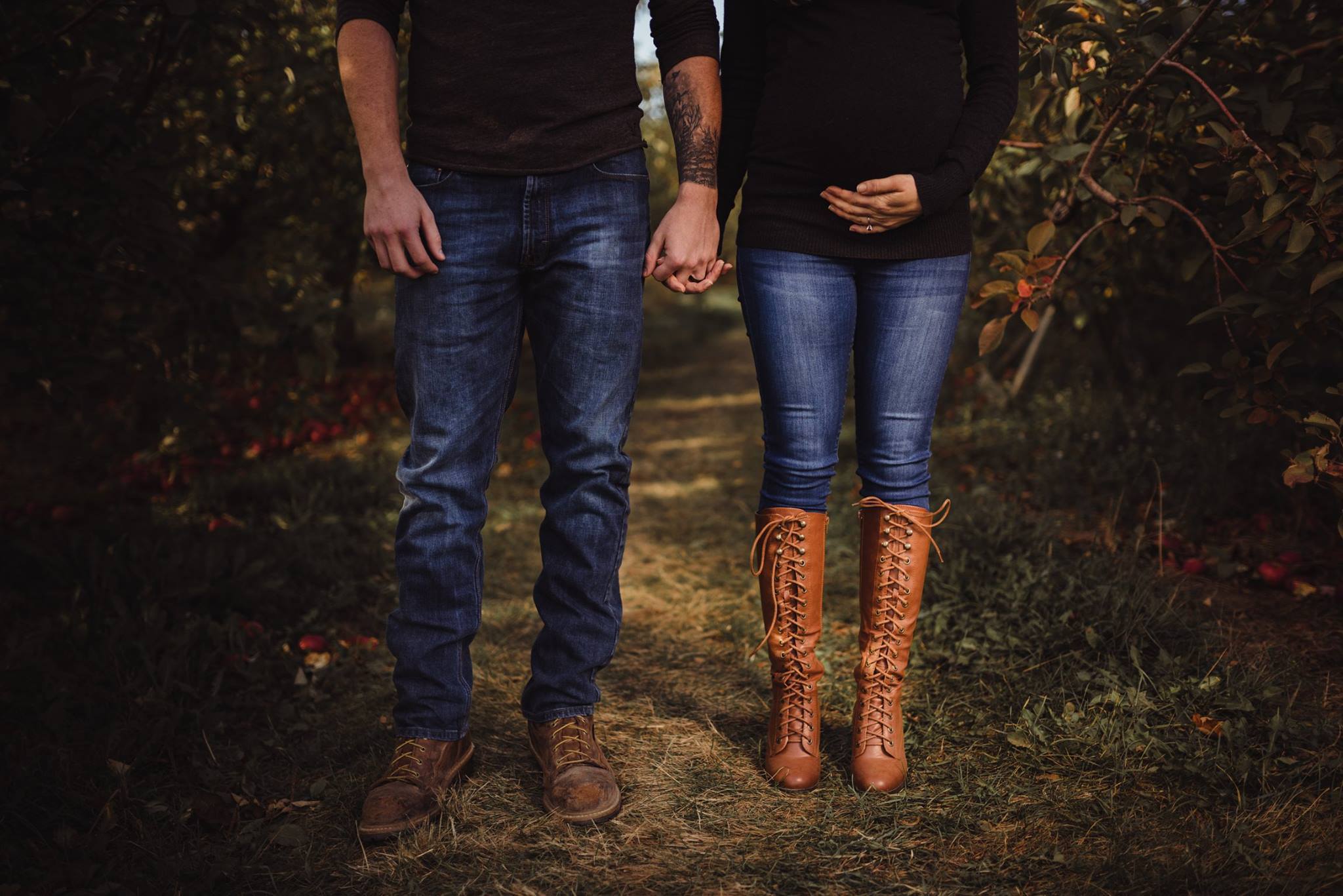 Couple with jeans and black shirt pose for maternity photos