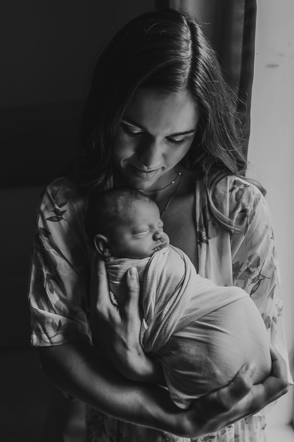 Black and white newborn photo of mother holding baby