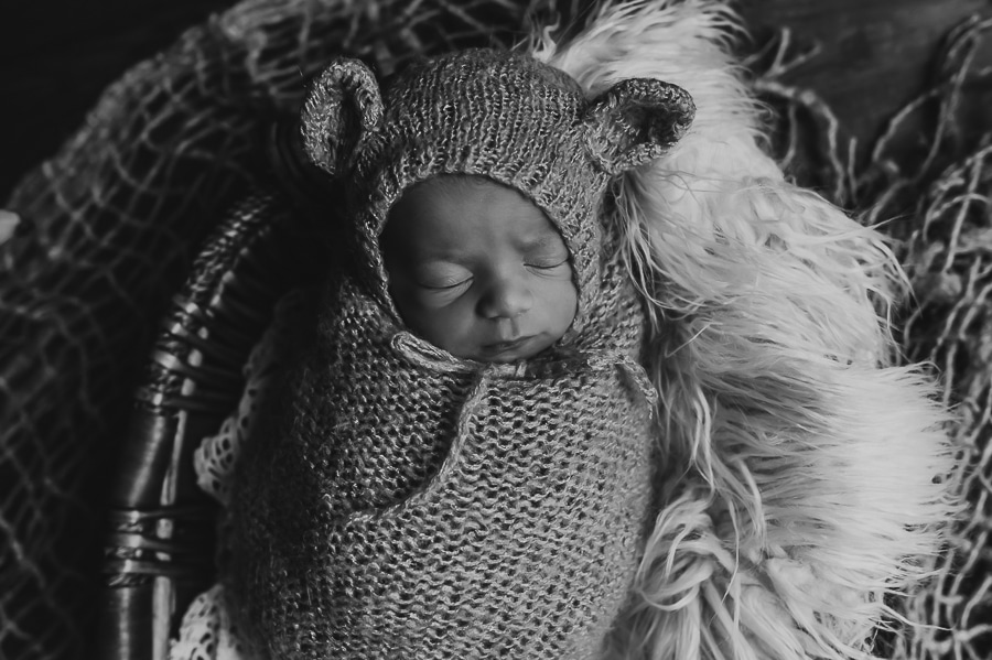 Black and white newborn posed photo of baby in bear outfit