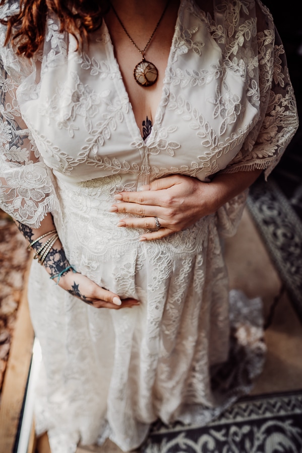 Bride holding pregnant stomach before wedding