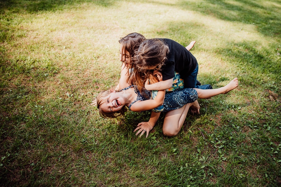 Children hugging and playing together on grass