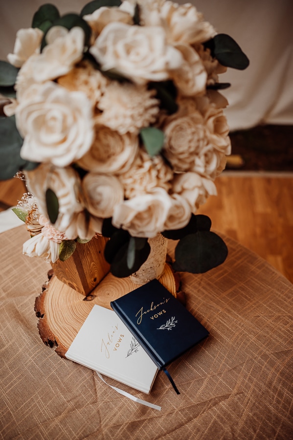 Bride and grooms vow books with flowers on table
