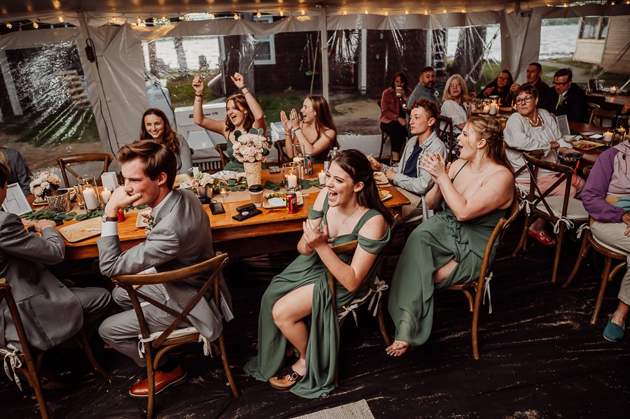 Bridal party sitting at tables cheering and celebrating