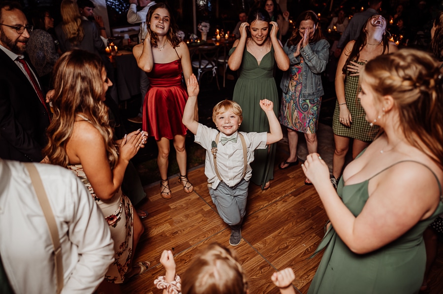 Little blond boy dancing in crowd at wedding