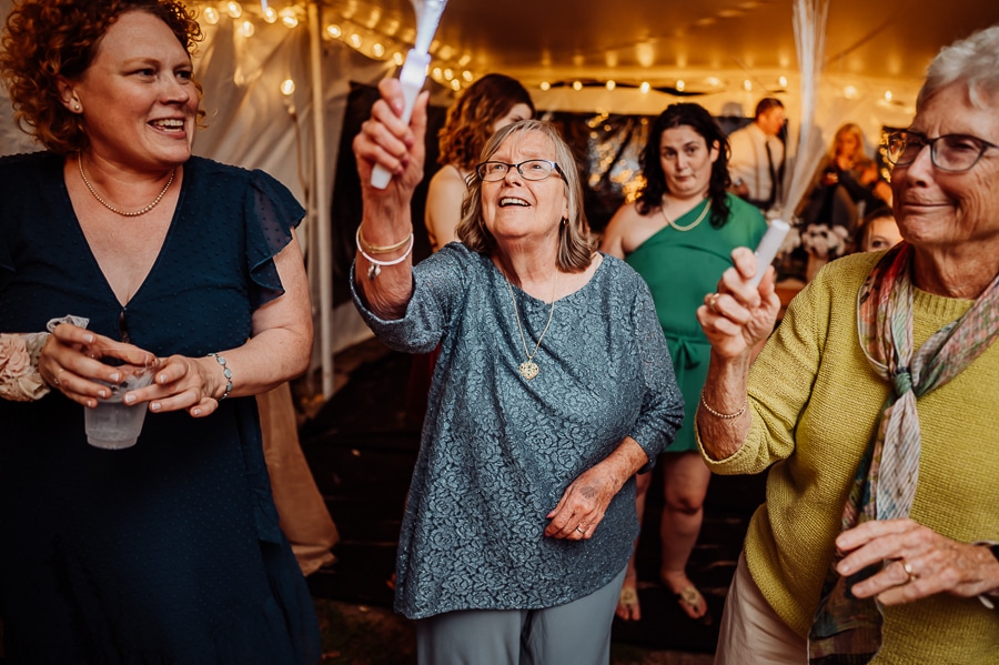 Grandmother in blue outfit dancing with sparkler on dance floor