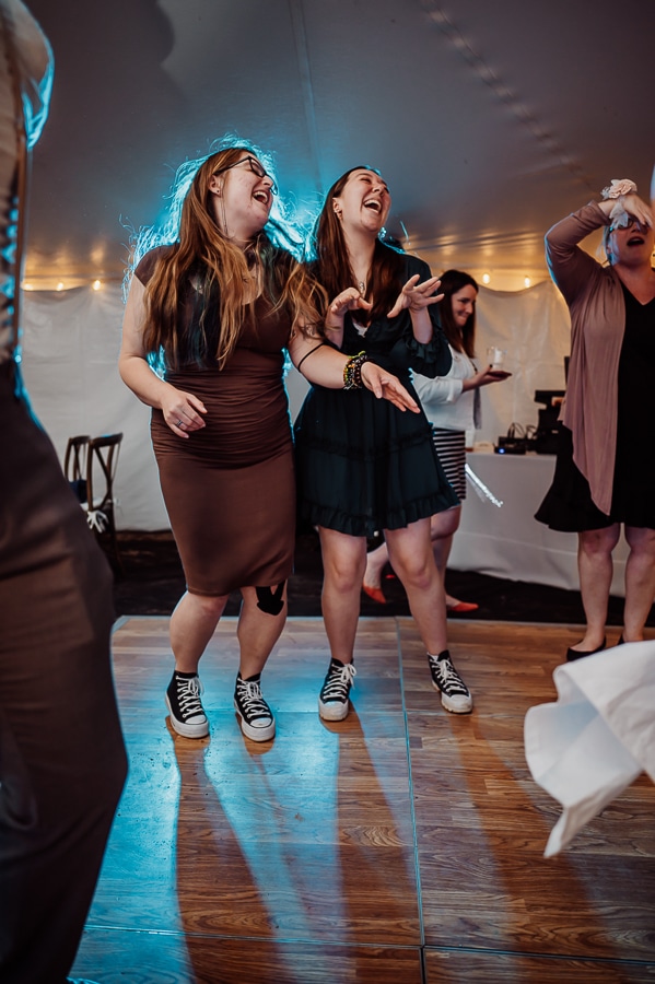 Women in dresses dancing on dance floor at wedding