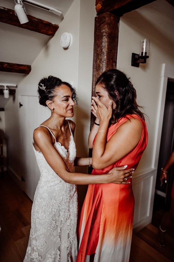 Two women crying and hugging before wedding