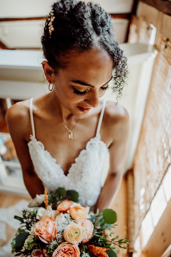 Bride holding flowers in wedding dress at clarks cove farm wedding