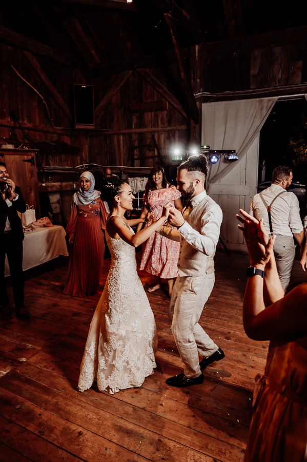 Bride and groom dancing in the middle of the dance floor with guests