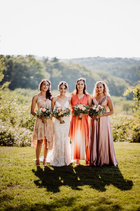 Bridesmaids in different pink dresses at clarks cove farm inn