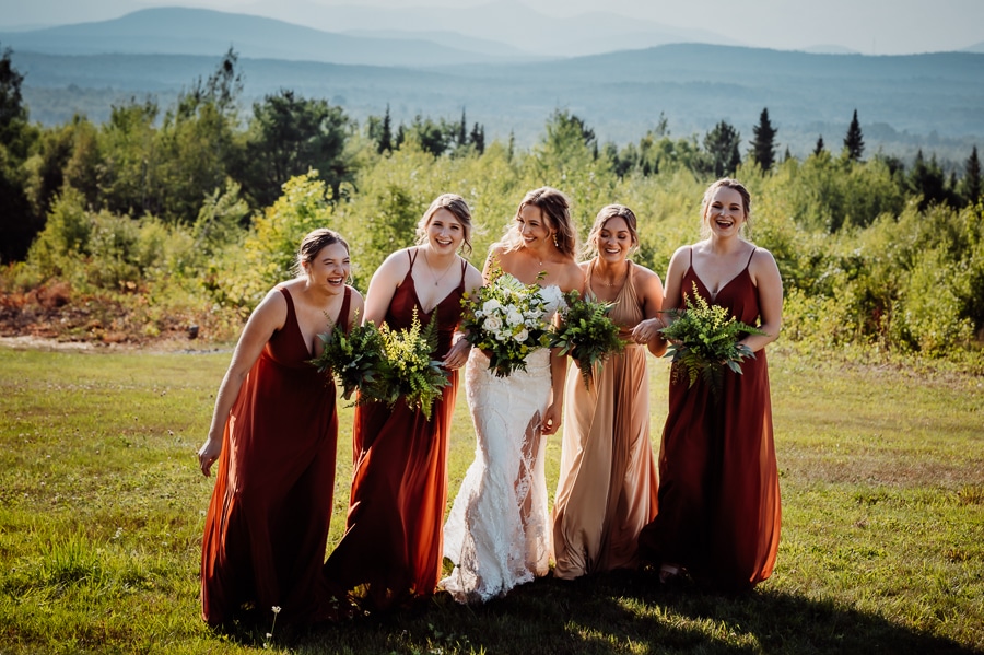 Bridesmaids walking together and laughing with robbins hill scenic overlook in background