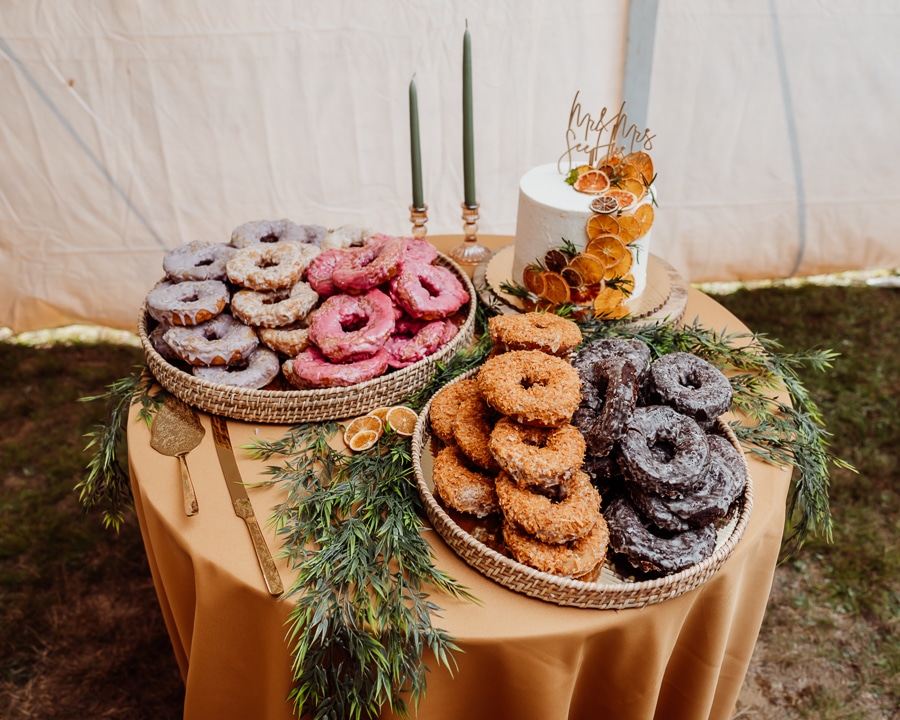 Holy Donut variety display with wedding cake on table