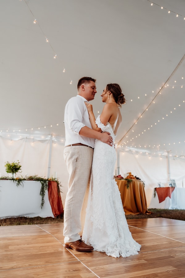 Bride and groom having first dance at wedding under tent