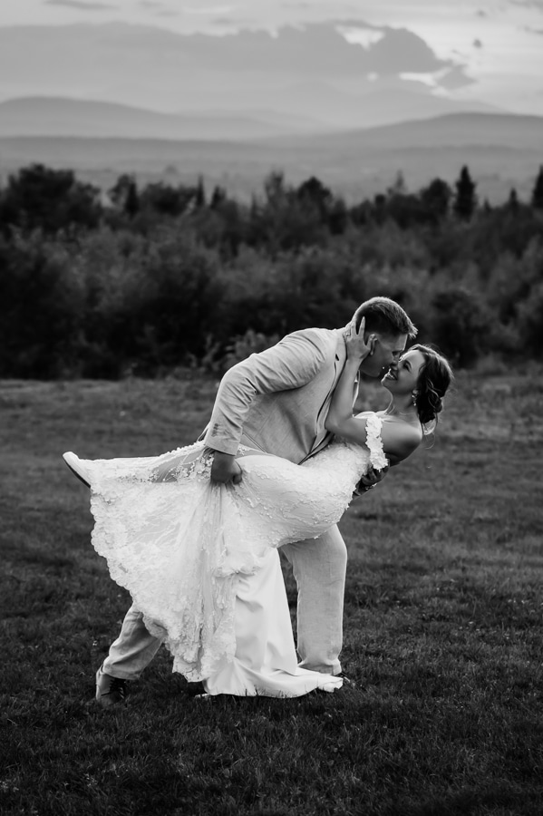 Black and white photo of groom dipping bride and kissing
