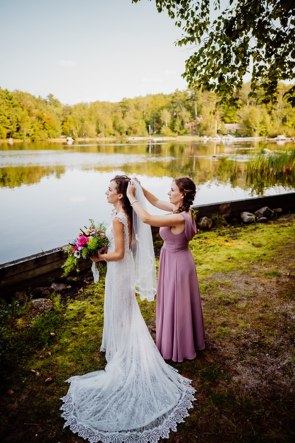 bridesmaid putting veil in brides hair at big moose inn