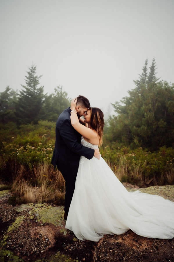Wedding couple embracing each other in fog on cadillac mountain