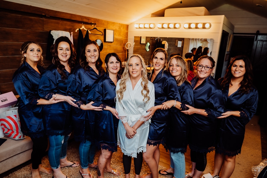 Bridesmaids together inside cabin with wedding robes