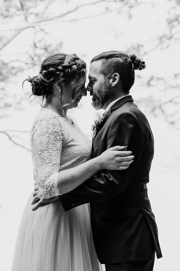 bride and groom facing and touching foreheads in black and white