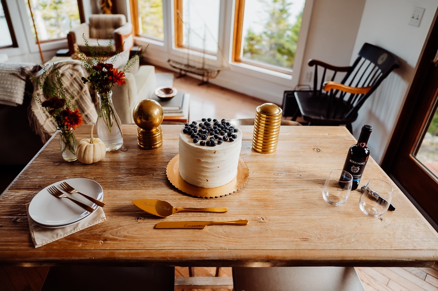 Wedding cake with blueberries sitting on table in machiasport airbnb