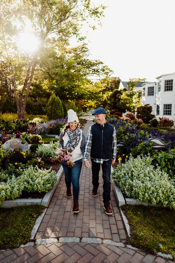 Woman and man wearing vests, plaid and hats walking in bar harbor garden