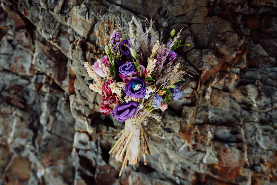 Wedding Bouquet laying on rocks with rings