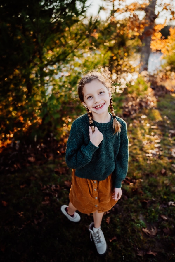 Little blonde girl with green sweater and orange skirt